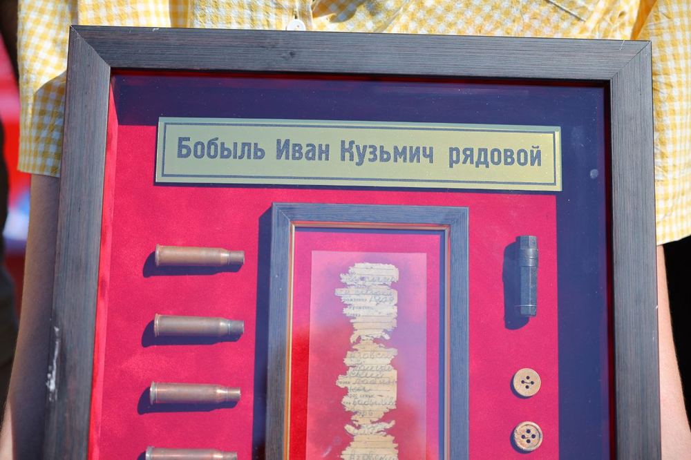 Памятная рамка с личными вещами Бобыля Ивана Кузьмича: в центре фрагмент записки из медальона